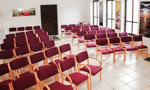 Ein Trauerfeierraum mit Stühlen für den letzten Abschied vom Verstorbenen. Würdiger Abschied im Bestatterhaus.