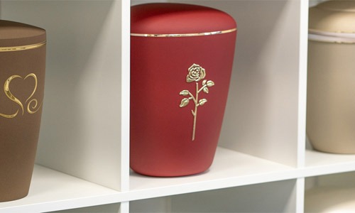 Ein Urne inmitten von Kerzen und Blumen. Trauerarrangement. Auch mit einem Altar möglich.